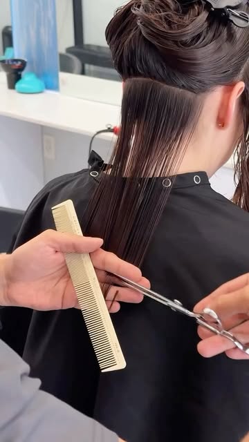 Mid-cut: the top section clipped up, the lengths cut with a comb and shears.